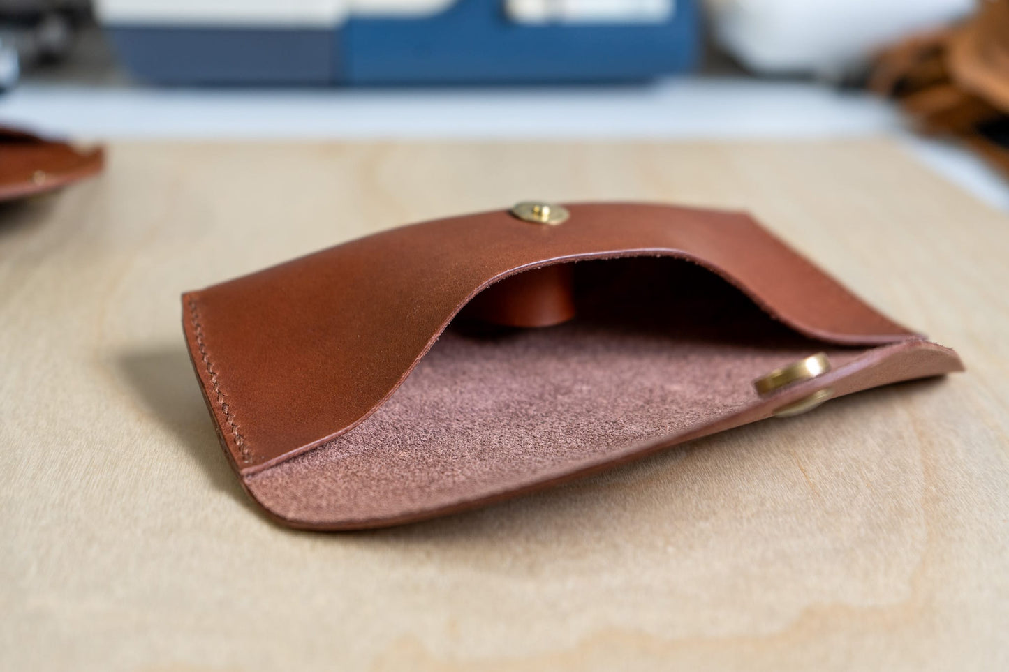 brown leather sunglass case shown inside on a wooden surface