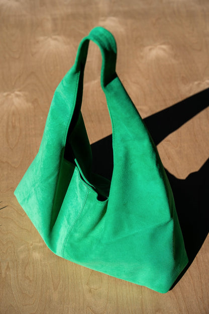 Green handbag on a wooden surface