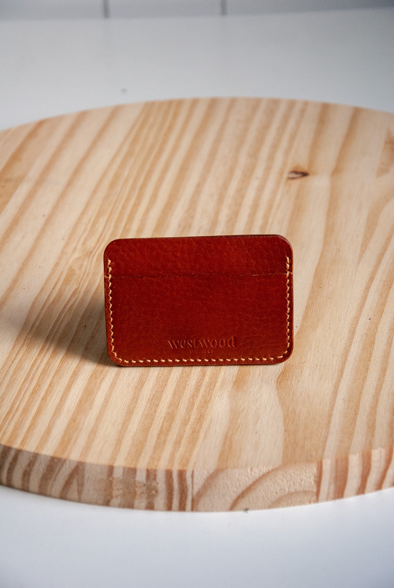 Brown leather cardholder on a wooden surface