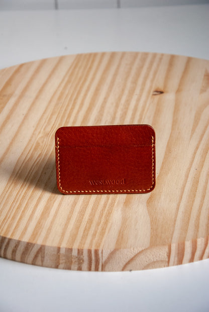 Brown leather cardholder on a wooden surface