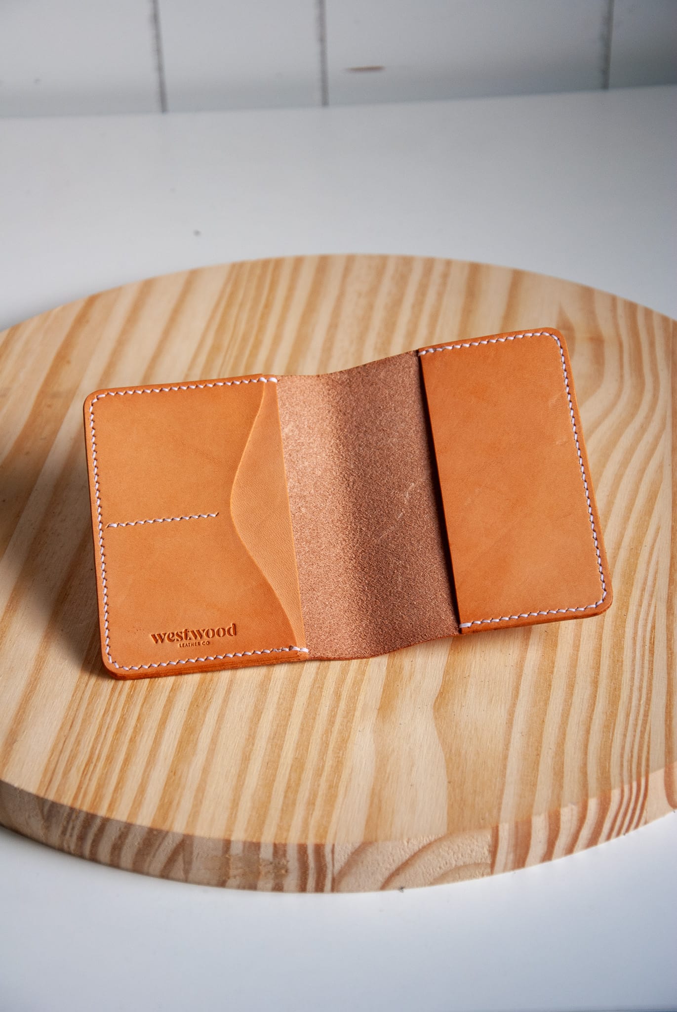 Tan leather wallet on a wooden surface
