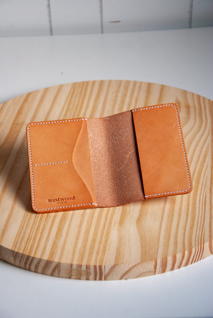 Tan leather wallet on a wooden surface