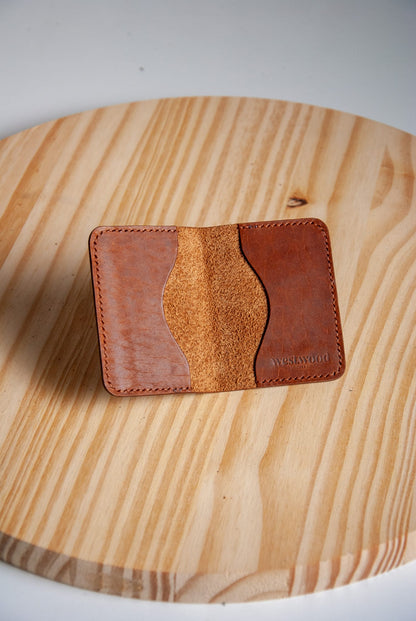 Brown leather cardholder on a wooden surface